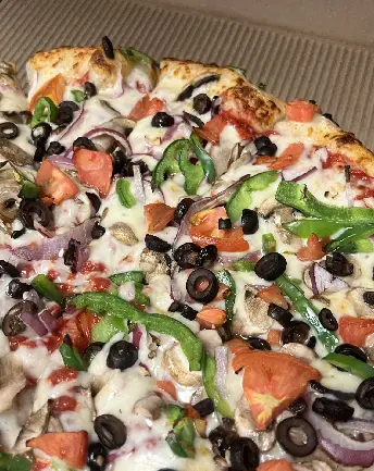 A pizza with olives, tomatoes and cheese on it.