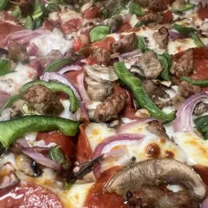 A close up of some pizza with mushrooms and peppers