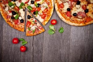 Pizza slices on rustic wooden table.